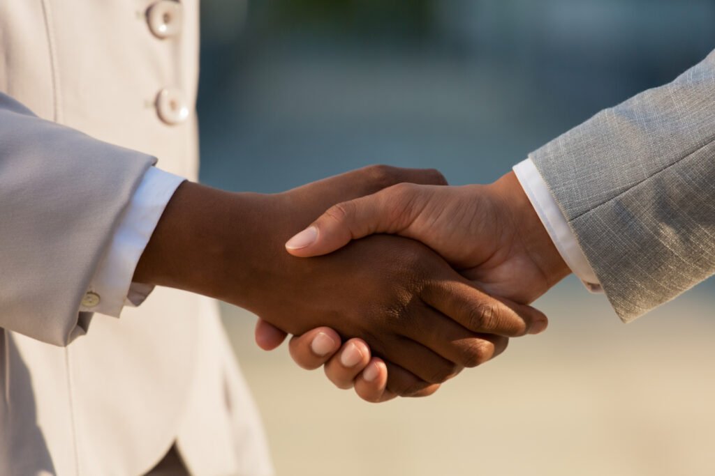 XTRM Group | Dark skinned businesswoman shaking hands with male colleague. Closeup of business people handshake. Agreement concept